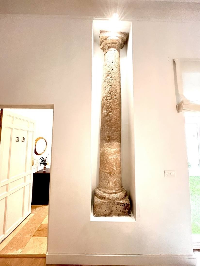 a white wall with a stone column in the corner