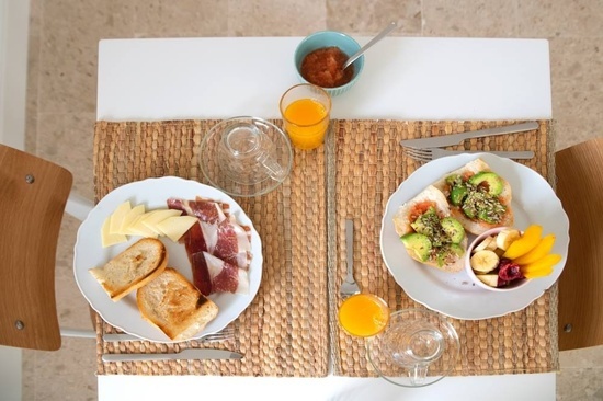 una mesa con platos de comida y un vaso de jugo de naranja