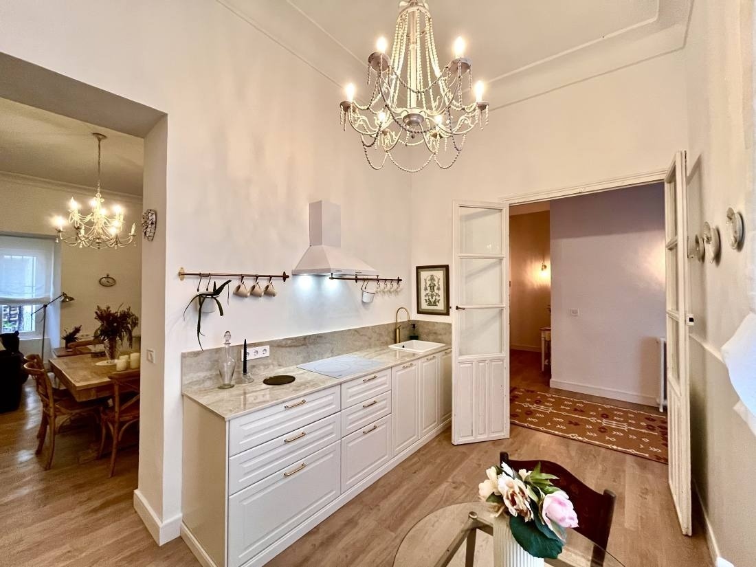 una cocina con gabinetes blancos y una lámpara de araña