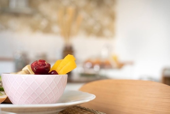 a bowl of fruit is on a plate on a table