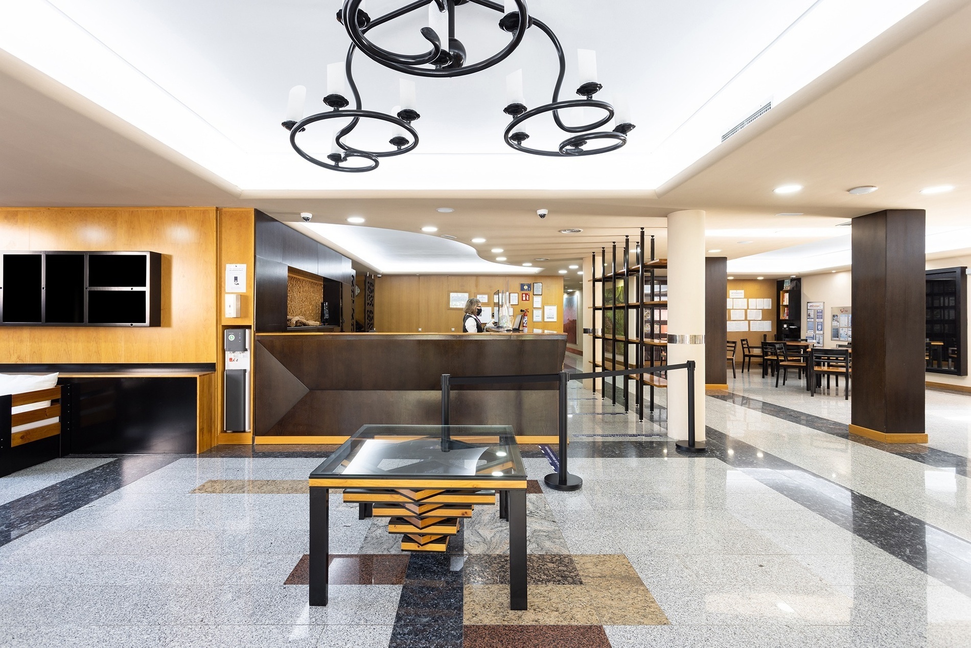 a reception desk in a hotel with a chandelier hanging from the ceiling