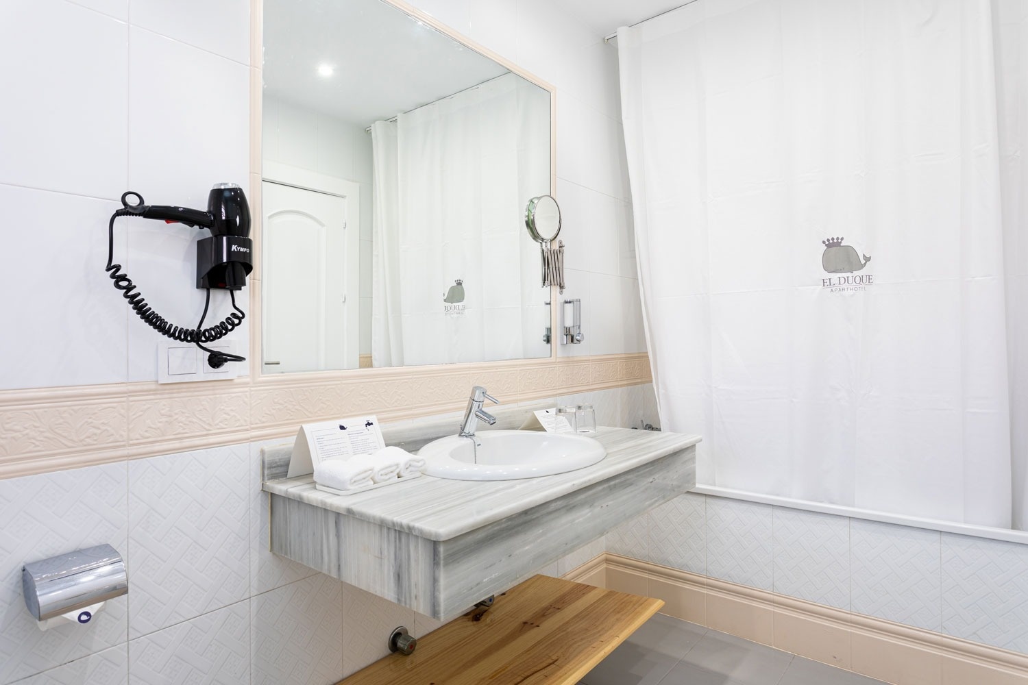 un cuarto de baño con un lavabo y un secador de pelo