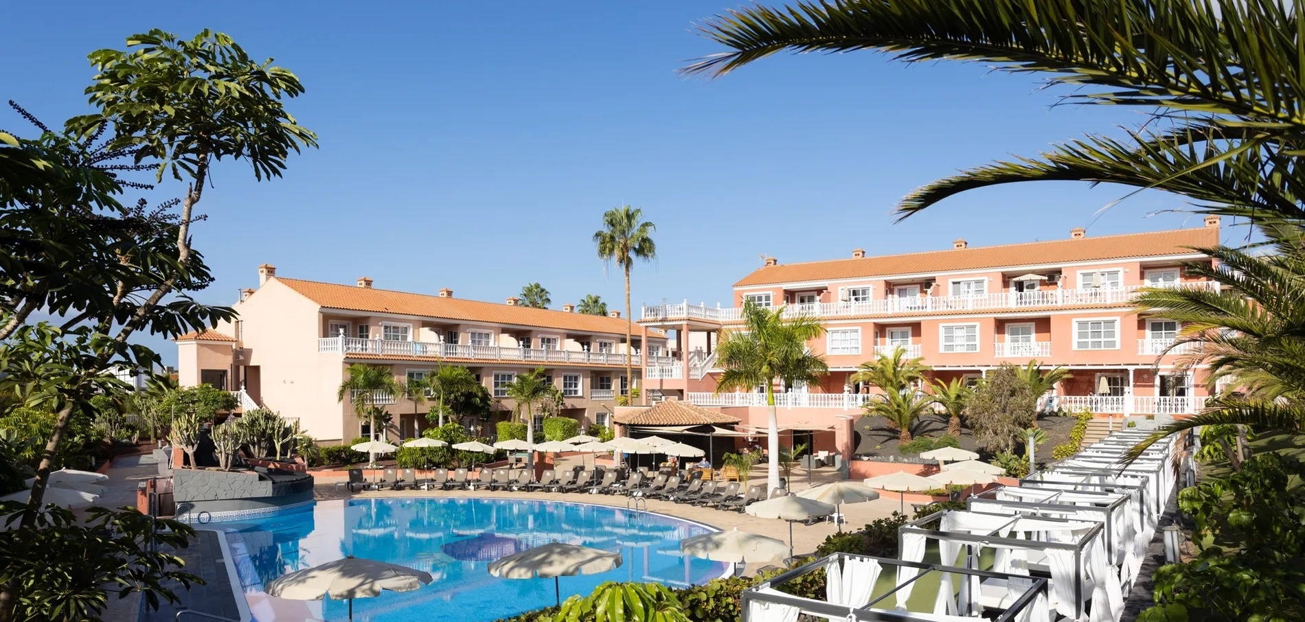 a large building with a lot of balconies and palm trees