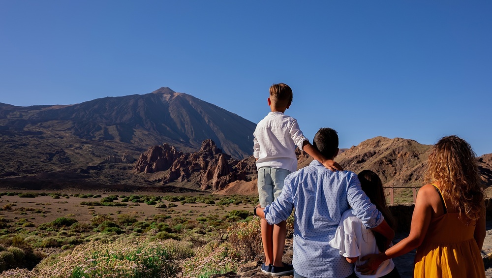 a family standing in front of a mountain looking at it