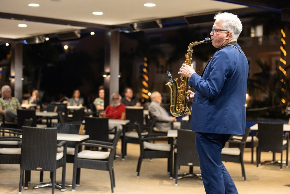 un hombre con traje azul toca un saxofón en un restaurante