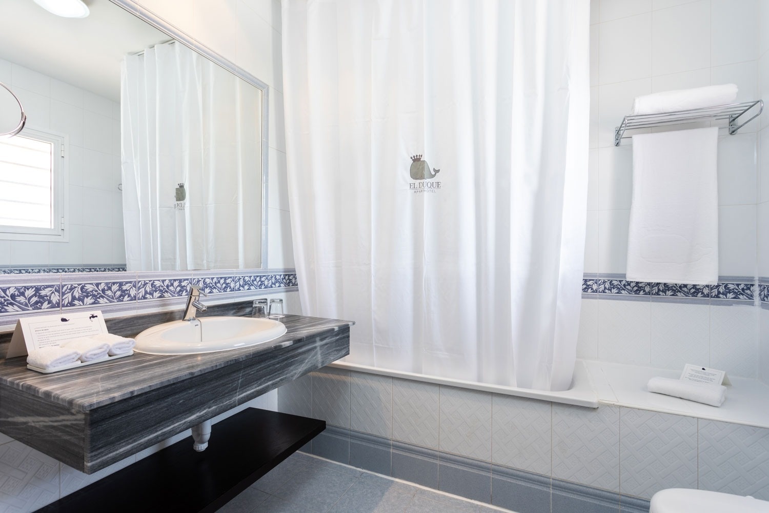 un cuarto de baño con una cortina de ducha blanca y un espejo