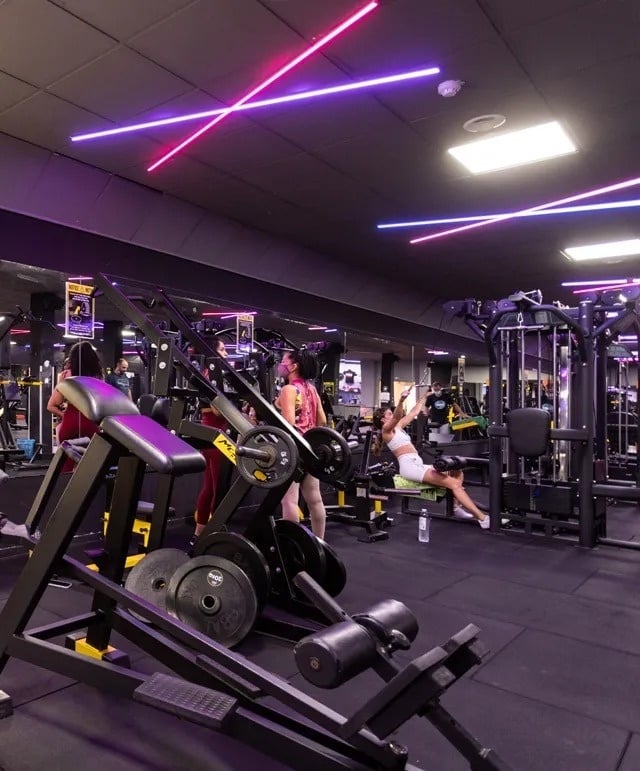 una mujer se sienta en una máquina de ejercicios en un gimnasio