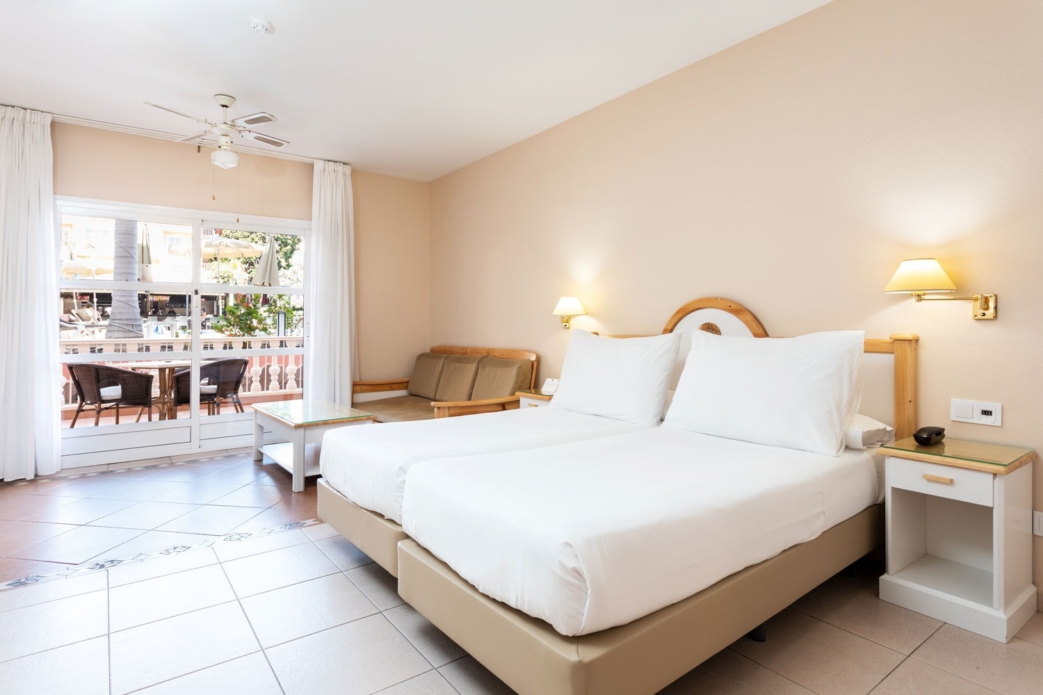 una habitación con dos camas y un ventilador de techo