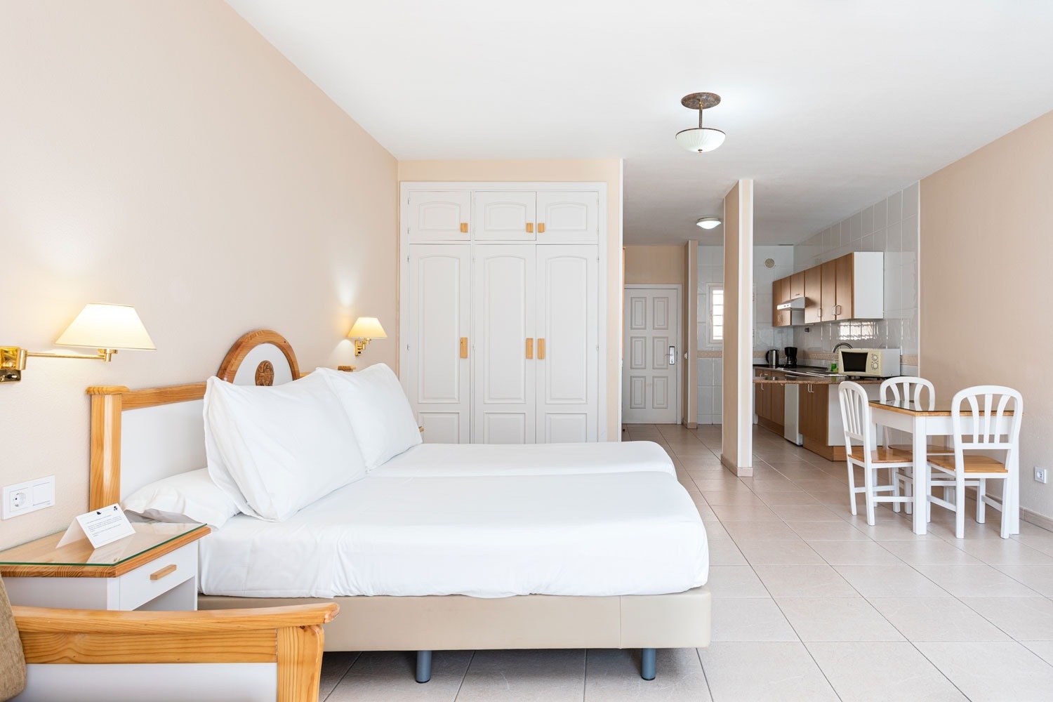 a hotel room with two beds and a table and chairs