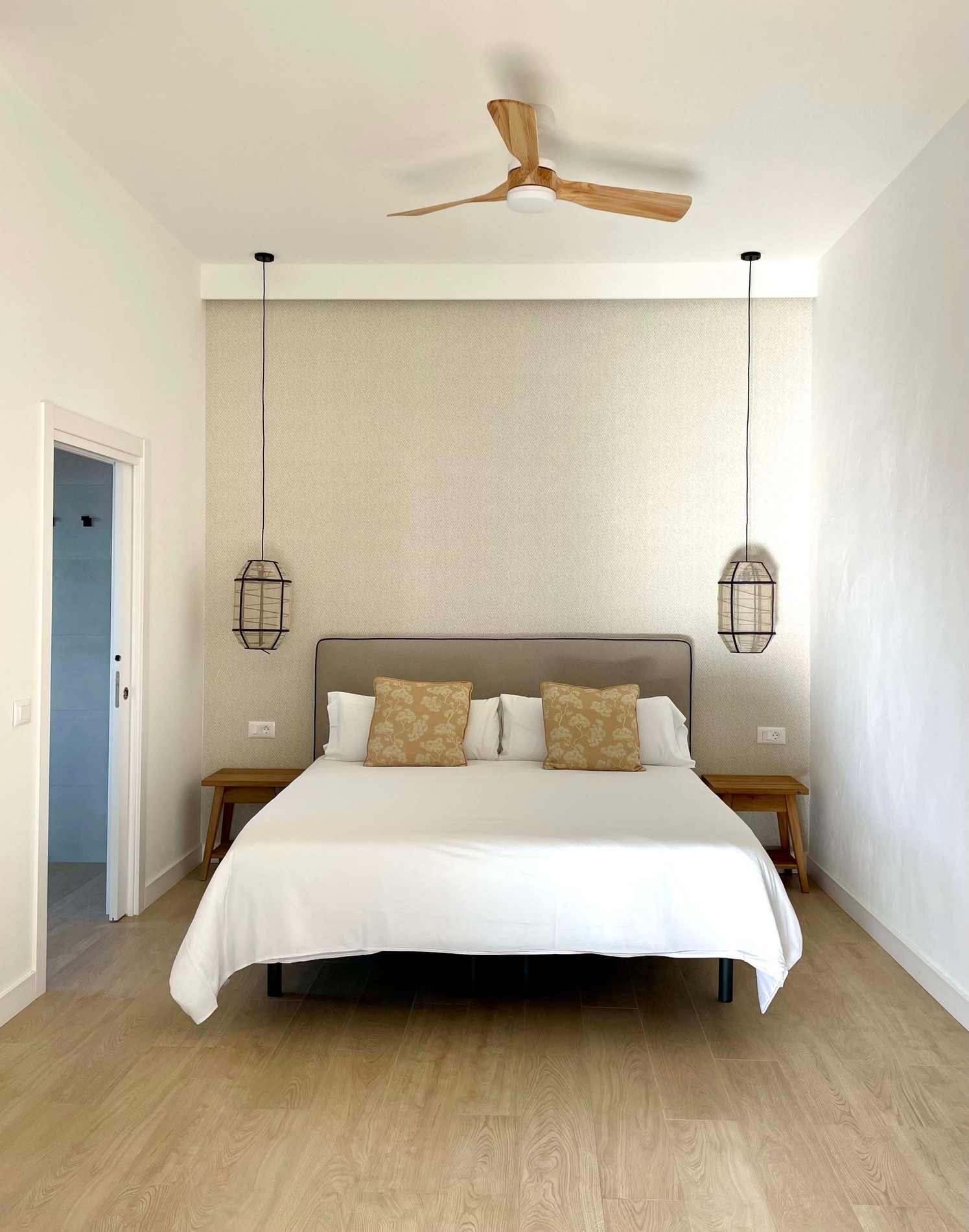 a bedroom with a large bed and a ceiling fan