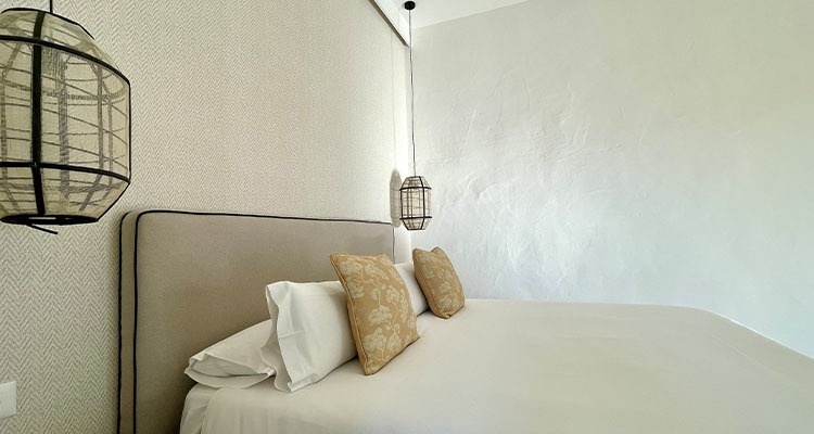 a bedroom with a bed and two lanterns hanging from the ceiling