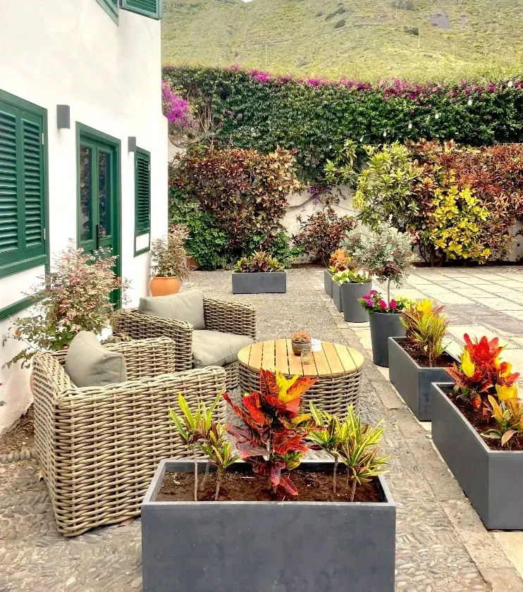 Gartenlounge des Hotels mit farbenfrohen Pflanzen und Bergblick El patio