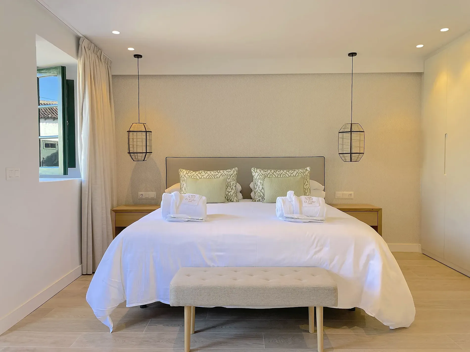 Hotelzimmer mit Doppelbett, Zugang zum Patio und Gartenblick.