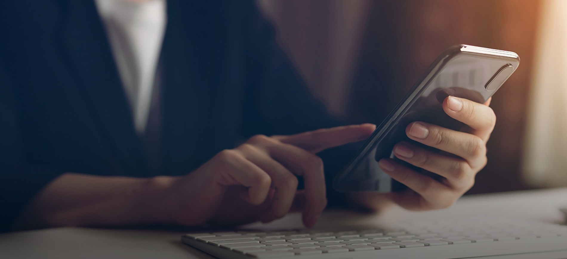 a woman is using a smart phone next to a keyboard