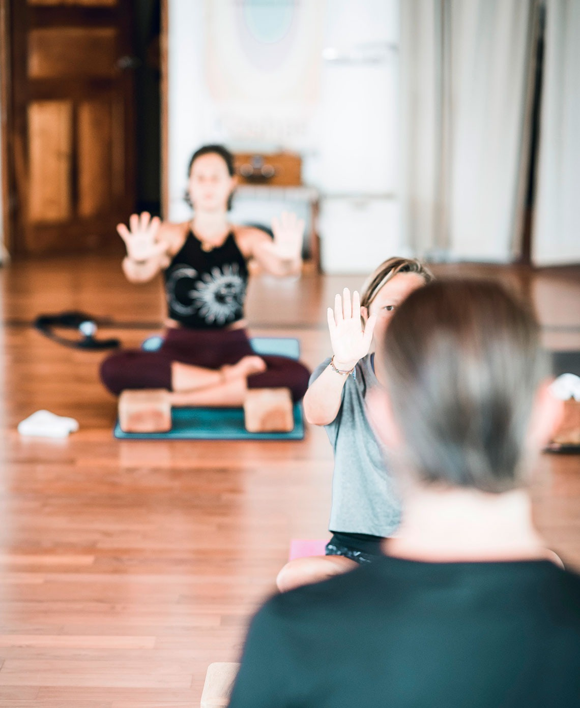 Yogastunde im El Patio des Hotels mit lehrenden und lernenden Personen in Meditation.