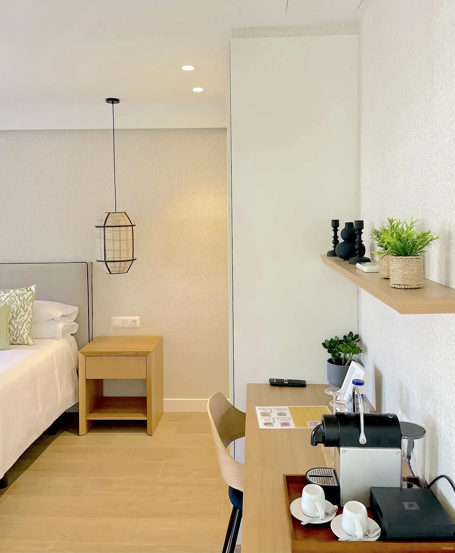 Modern Hotelzimmer mit Doppelbett, Nachttisch, Schreibtisch und Kaffeemaschine. El patio