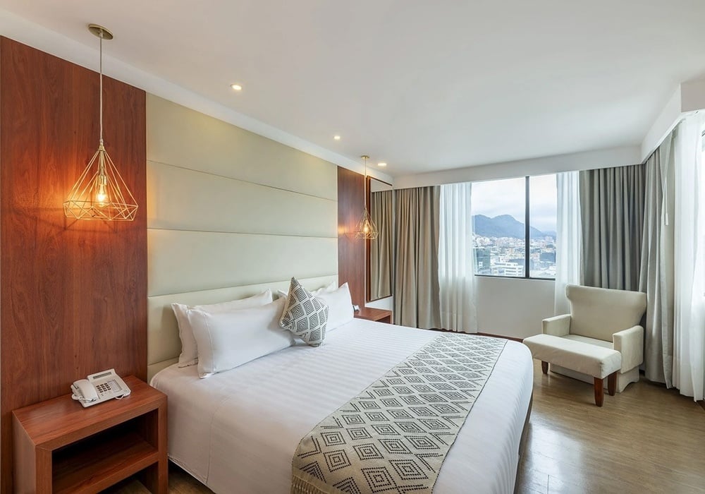 una habitación de hotel con una cama king size y una silla