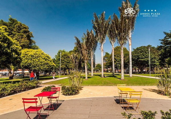 a park with tables and chairs and a sign that says andes plaza