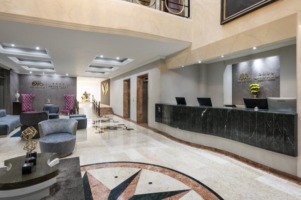 a hotel lobby with a marble counter and a sign that says ' hotel aurora plaza '