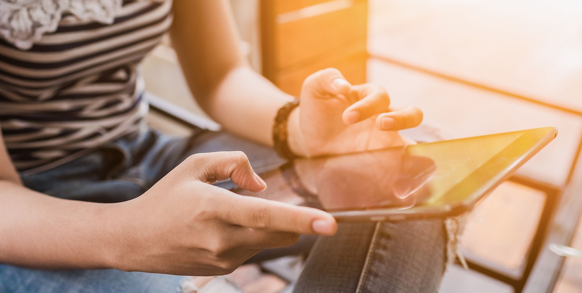 Cliente mirando en un iPad las recompensas de reservar en EM Hotels