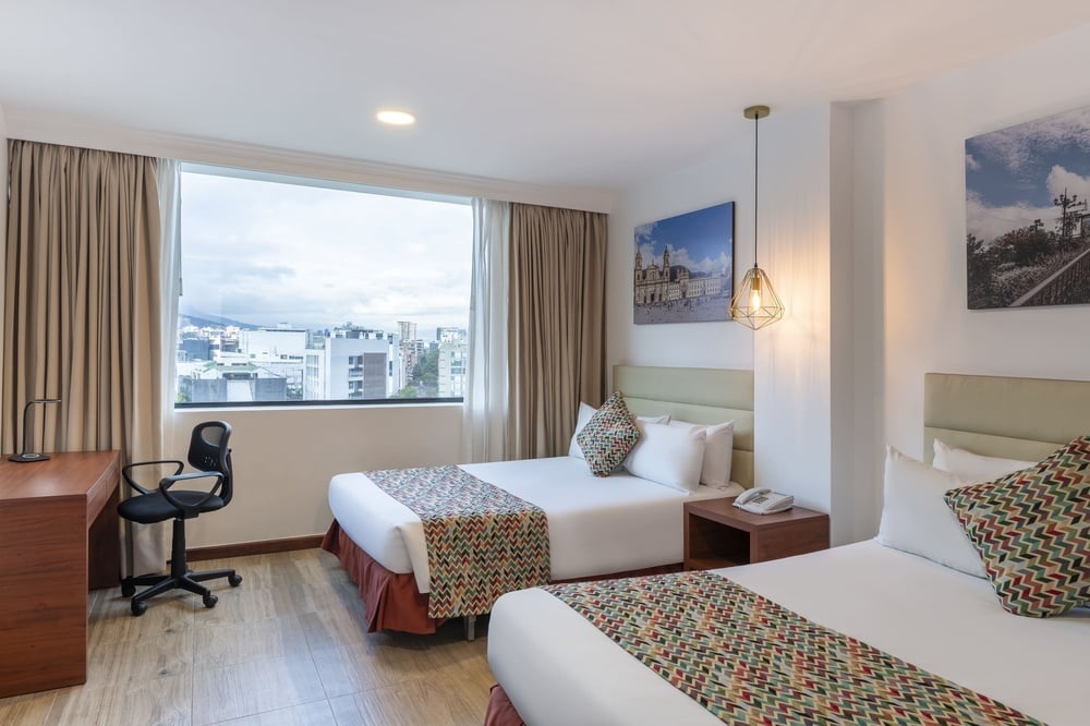 una habitación de hotel con dos camas y una ventana