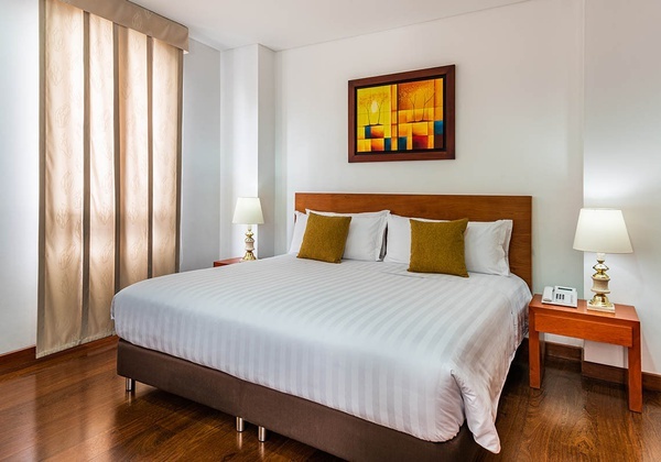 a hotel room with a bed and a painting on the wall