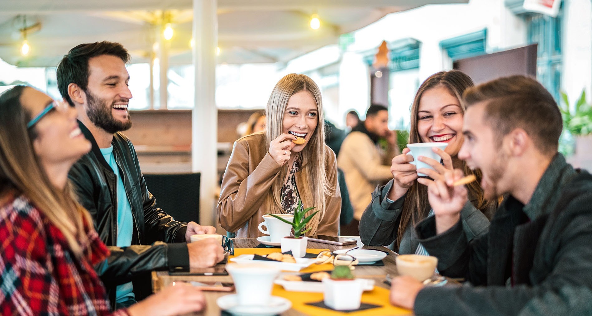 Amigos en la terraza de un bar sonriendo y disfrutando sus vacaciones 