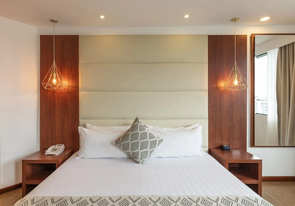 una habitación de hotel con una cama y dos mesitas de noche