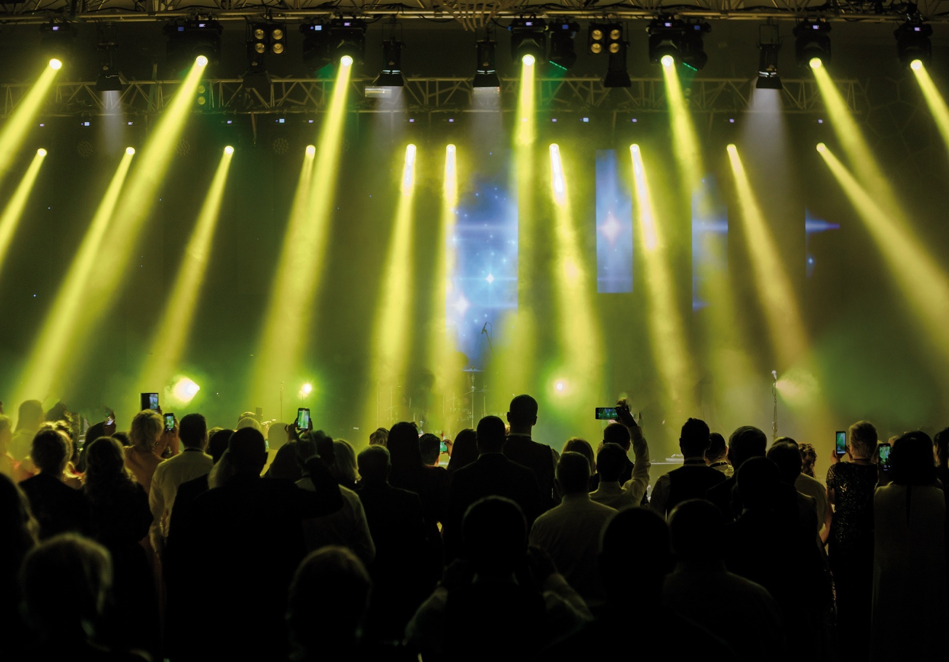 un grupo de personas en un concierto con luces amarillas y verdes