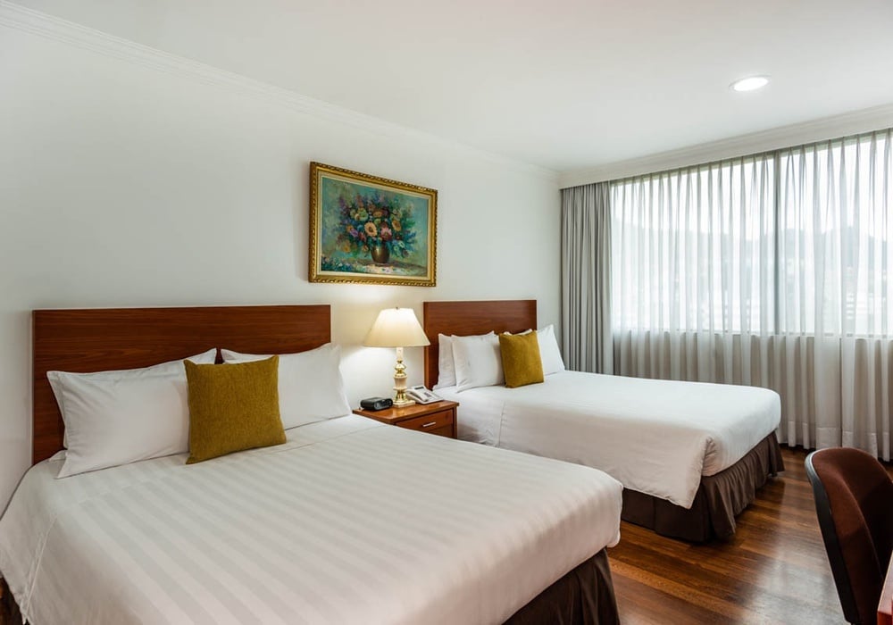una habitación de hotel con dos camas y una pintura en la pared