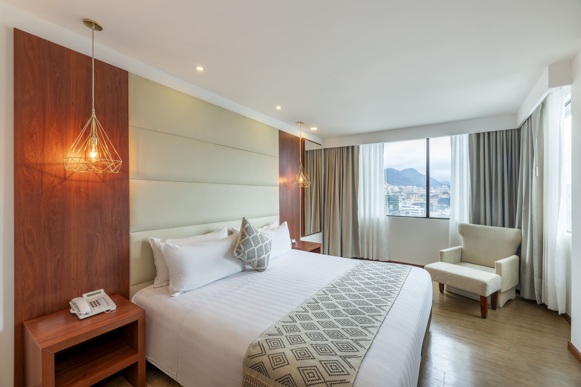 um quarto de hotel com uma cama king size e uma cadeira