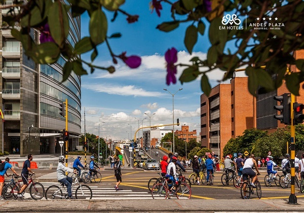 a group of people riding bikes on a street with the andes plaza hotel in the background