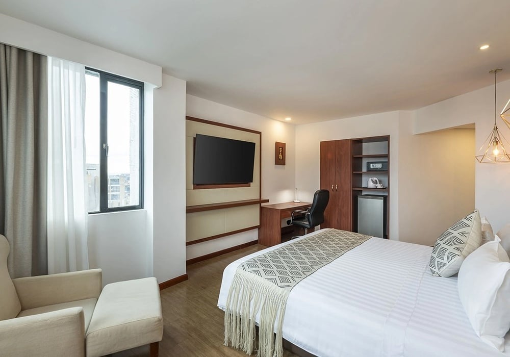 una habitación de hotel con una cama y una televisión