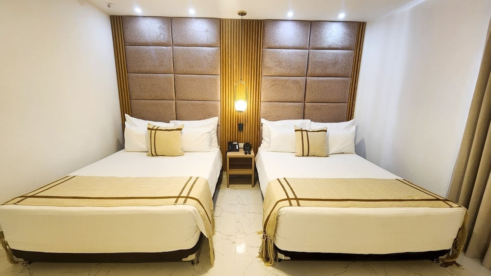 um quarto com duas camas e uma mesa de cabeceira