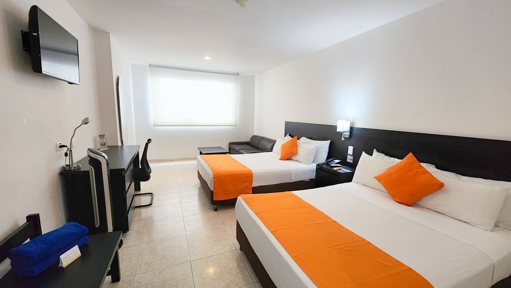 um quarto de hotel com duas camas e um sofá