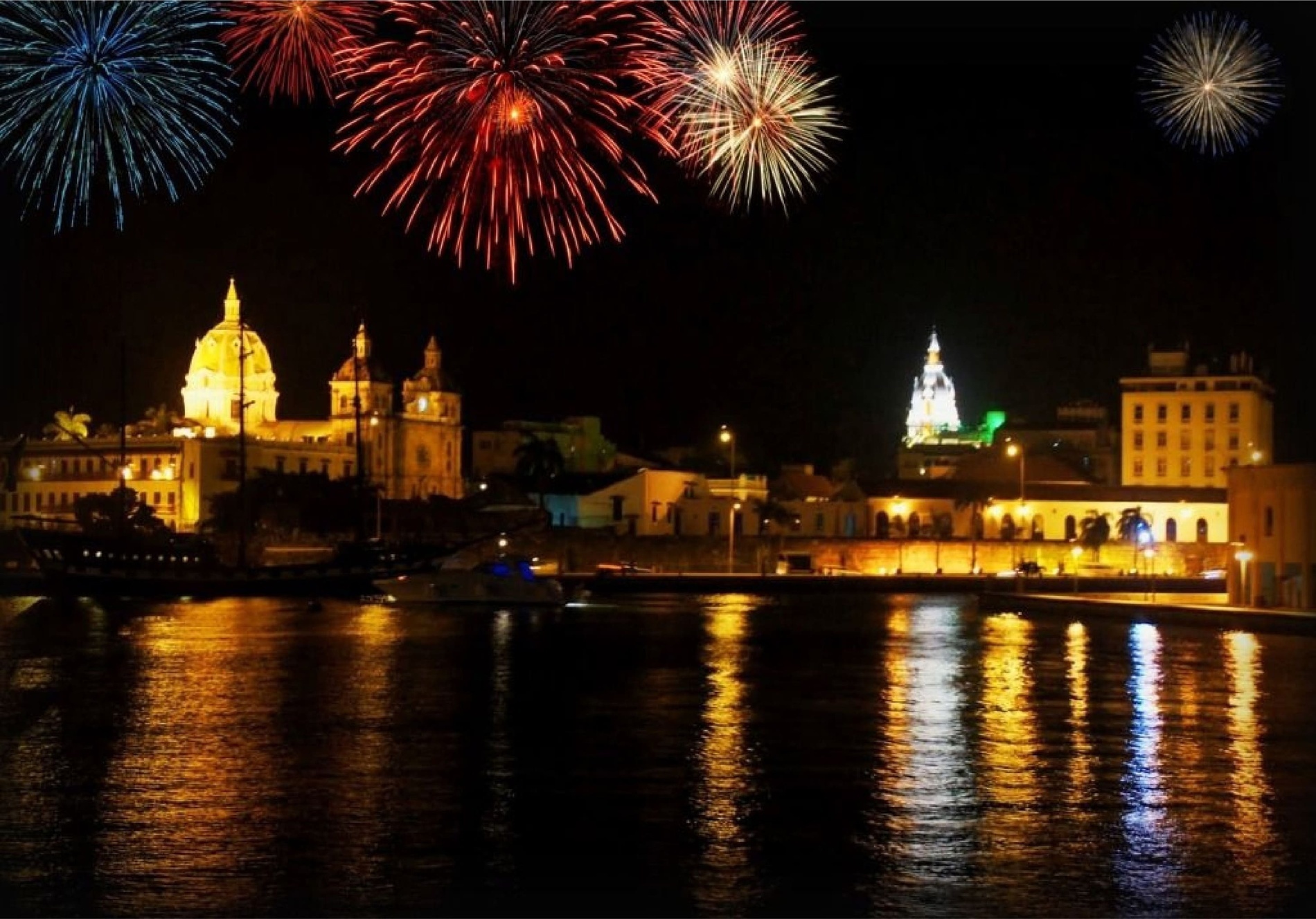fogos de artifício explodem sobre uma cidade à noite