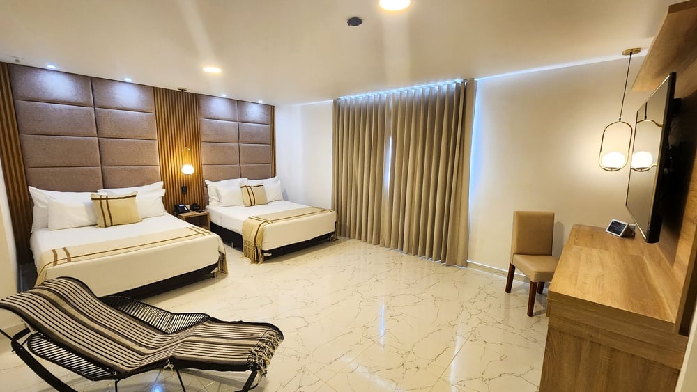um quarto de hotel com duas camas e uma cadeira