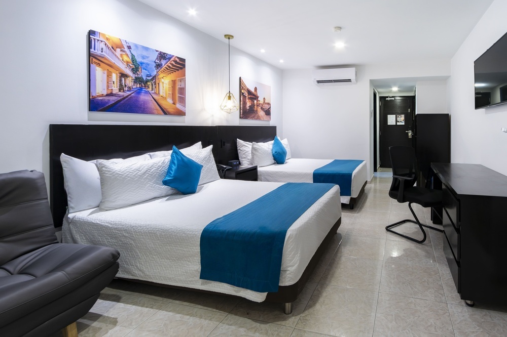 um quarto de hotel com duas camas e um sofá