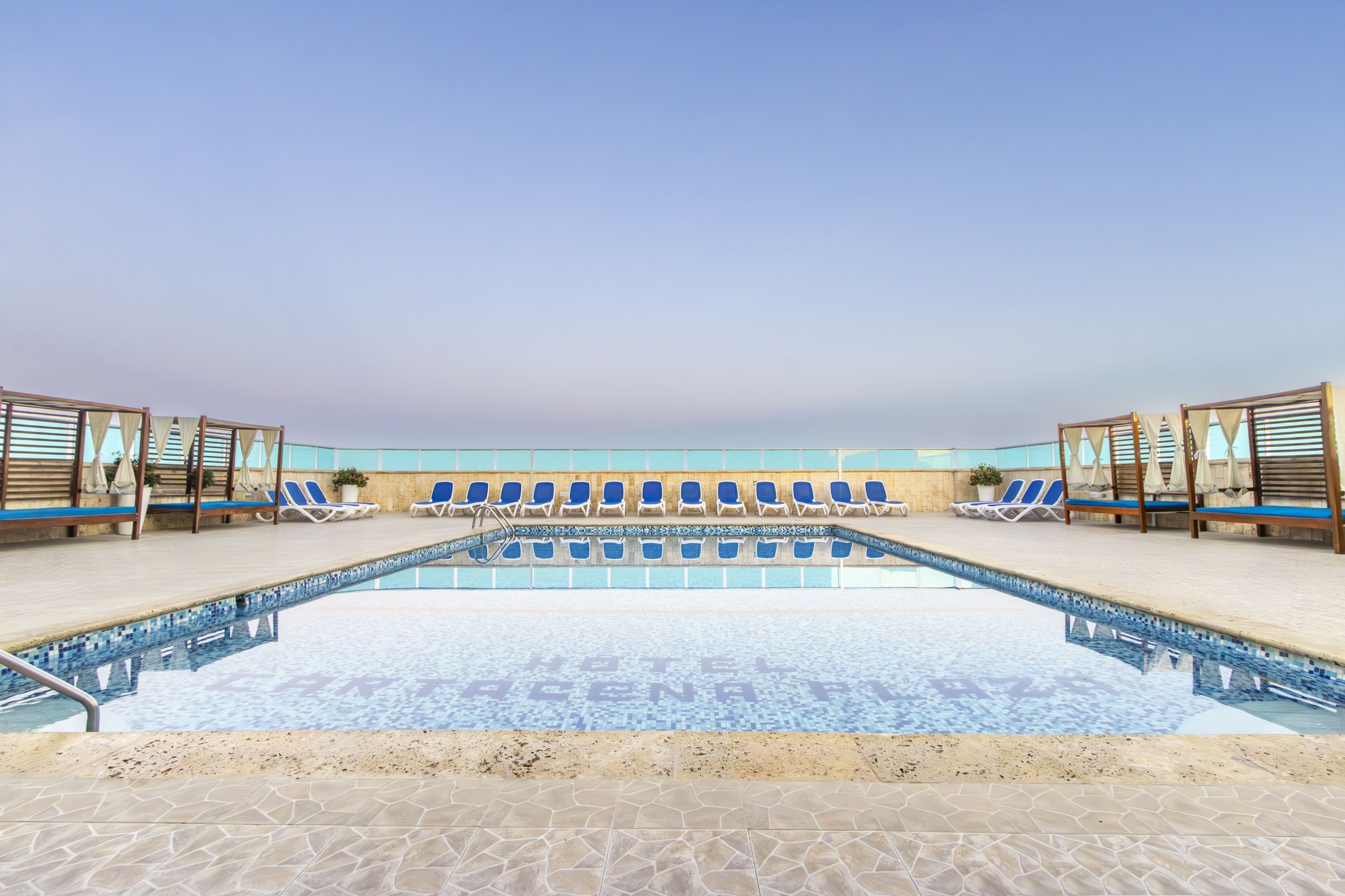 a swimming pool surrounded by chairs and a canopy