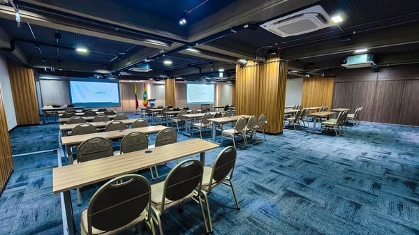 una sala de conferencias llena de mesas y sillas