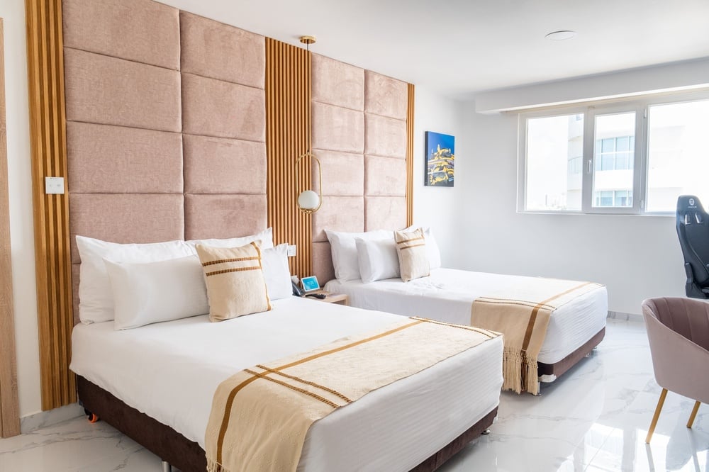um quarto de hotel com duas camas e uma janela