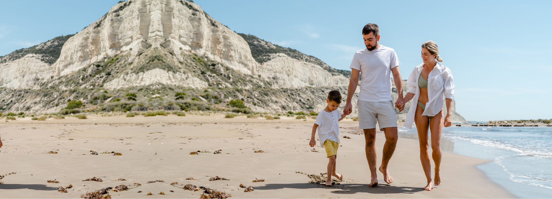 un hombre sostiene a una mujer en el aire en la playa