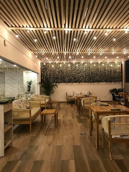 un restaurante lleno de mesas y sillas con un techo de madera