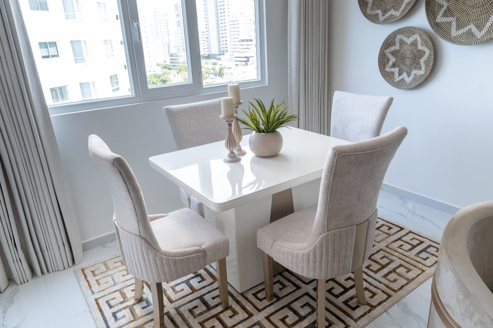 uma sala de jantar com uma mesa branca e cadeiras