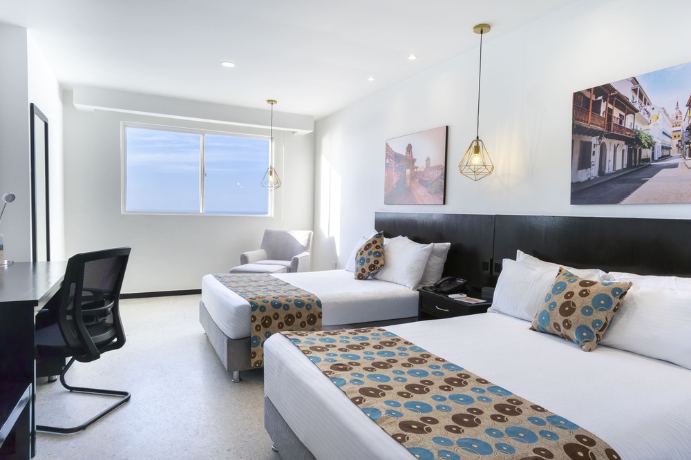 um quarto de hotel com duas camas e uma mesa