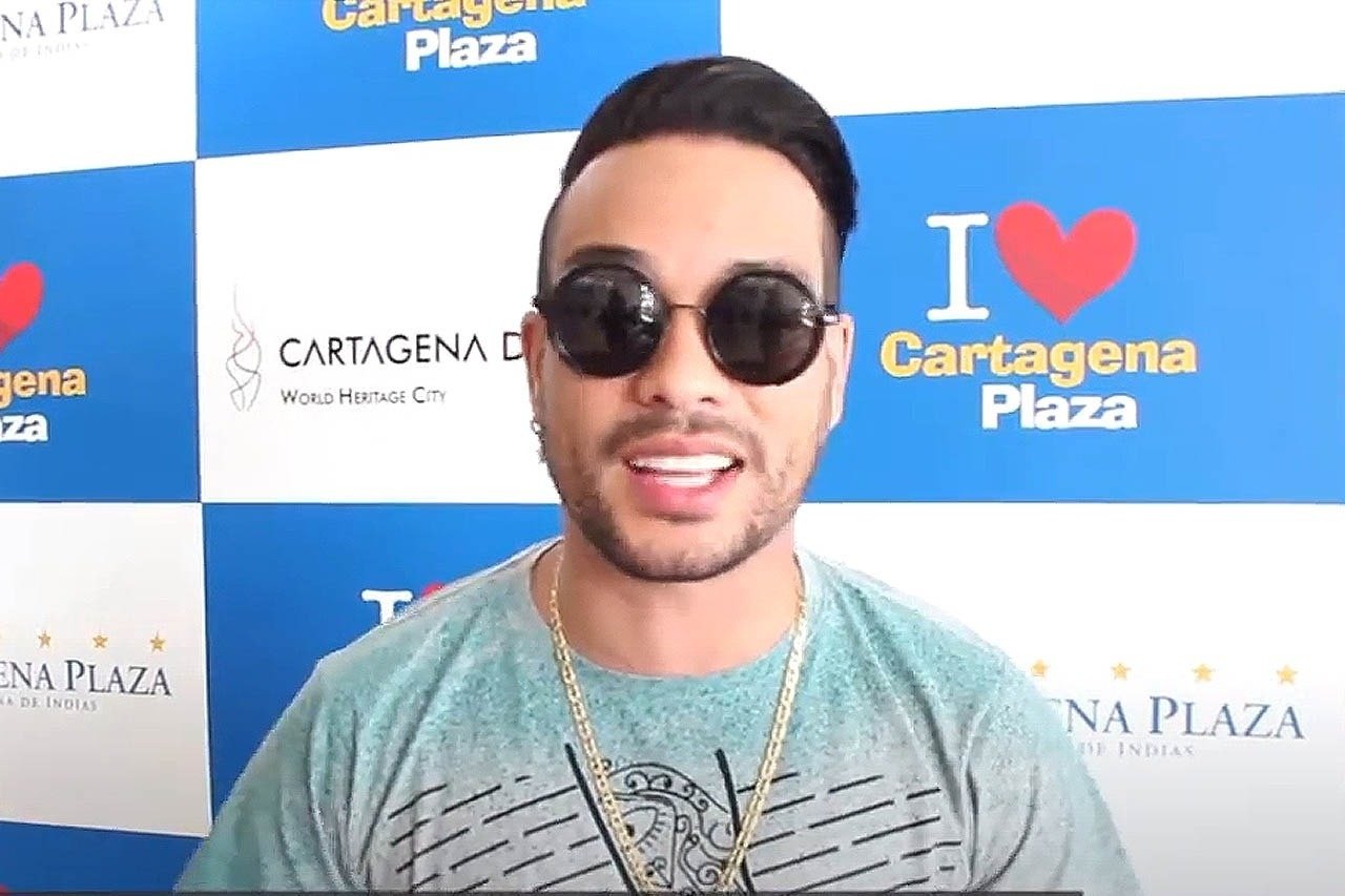 um homem usando óculos escuros e uma camisa que diz cartagena plaza