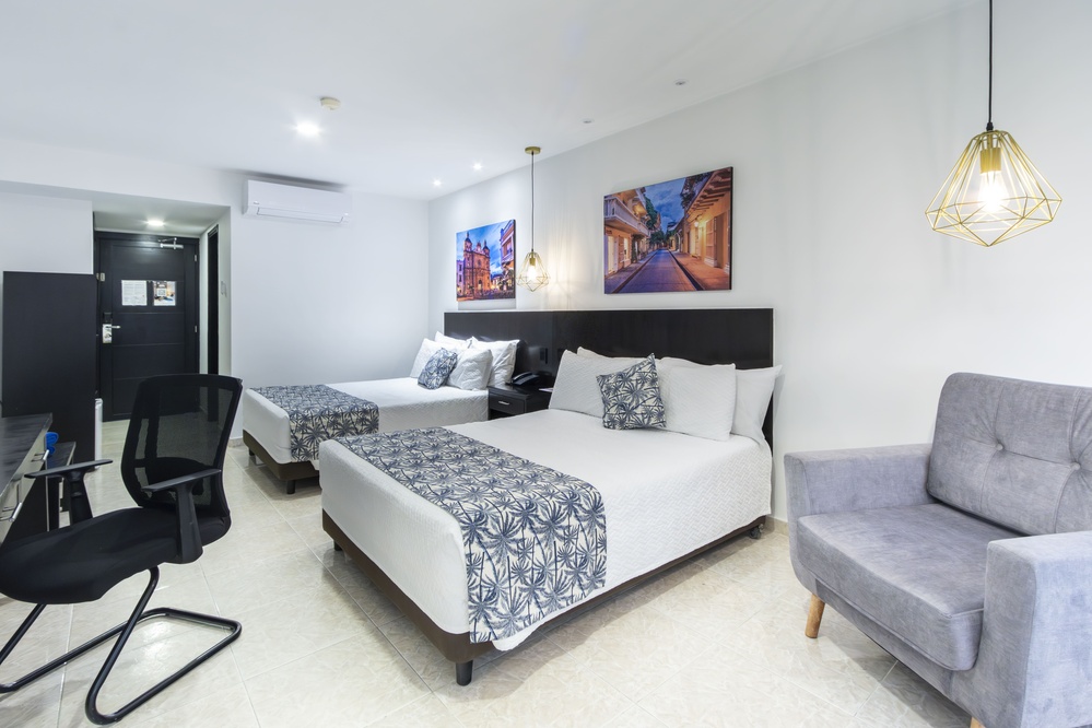 um quarto de hotel com duas camas e uma televisão