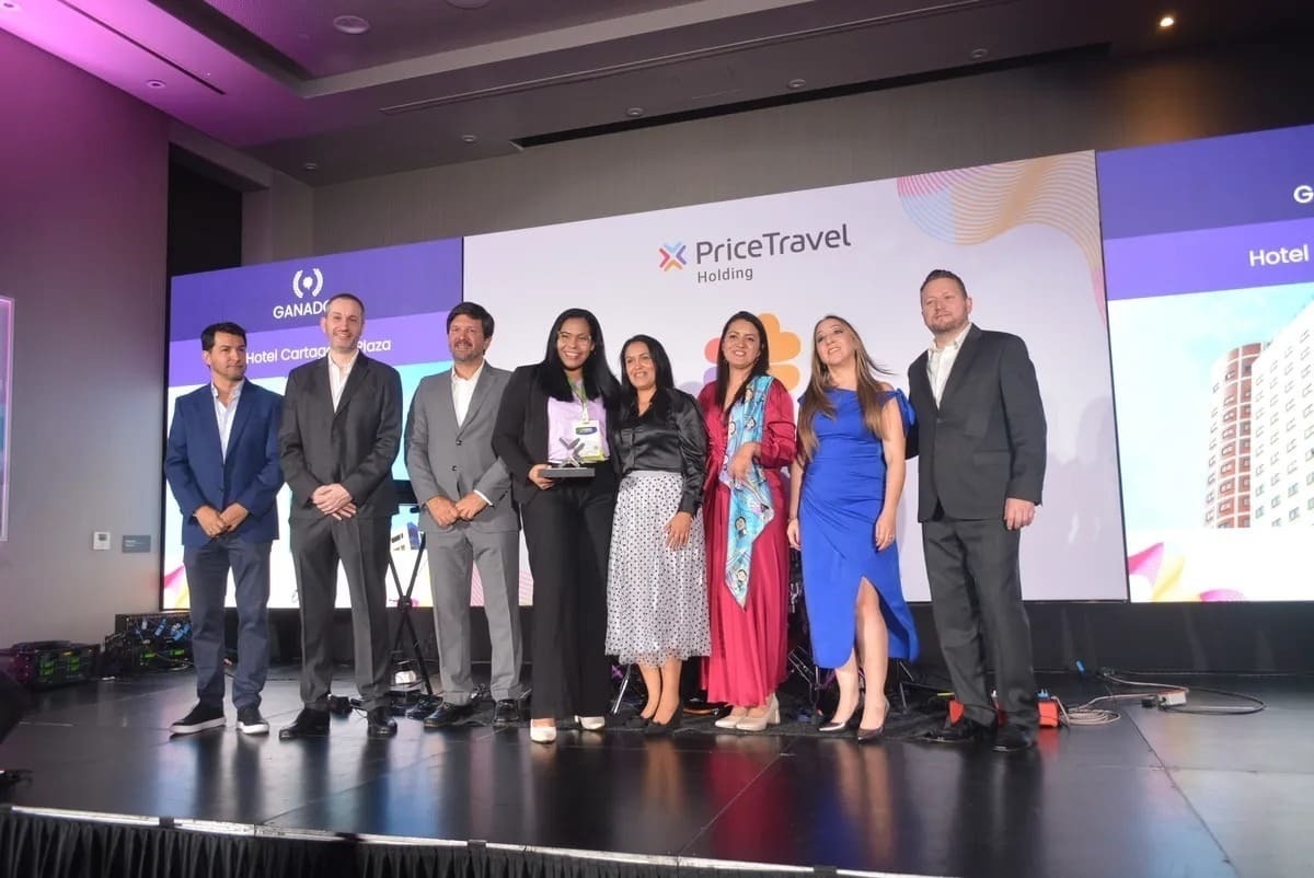 a group of people standing on a stage in front of a sign that says price travel holding