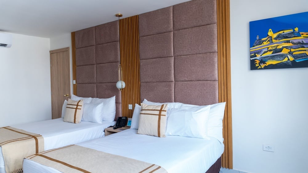 um quarto de hotel com duas camas e uma pintura na parede