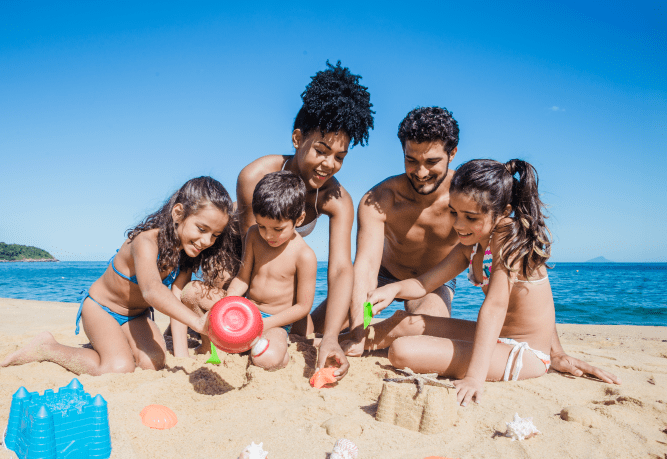 una familia construye castillos de arena en la playa